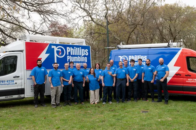 The Phillips Plumbing and Mechanical crew lined up in front of their service vans