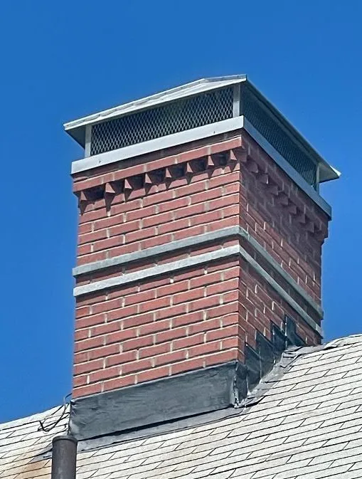 Full chimney rebuild with granite accents and hip and ridge cap