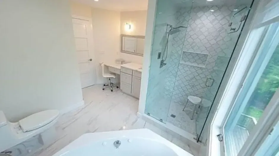 Spacious bathroom with glass shower, soaking tub, and vanity, located in the Greater Boston area