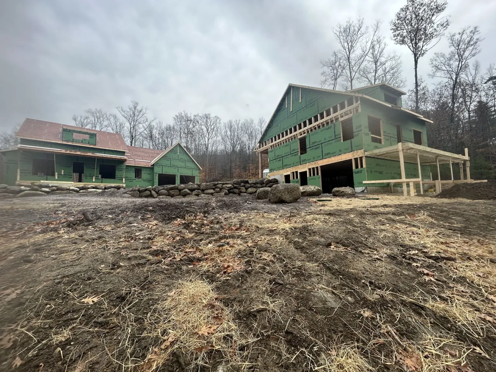 A large house is being built in the middle of a field.