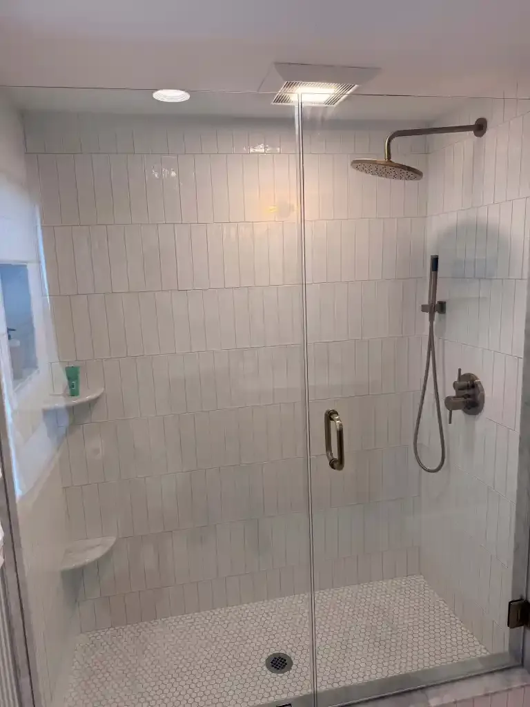Contemporary glass shower enclosure with rainfall showerhead.