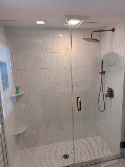 Contemporary glass shower enclosure with rainfall showerhead.