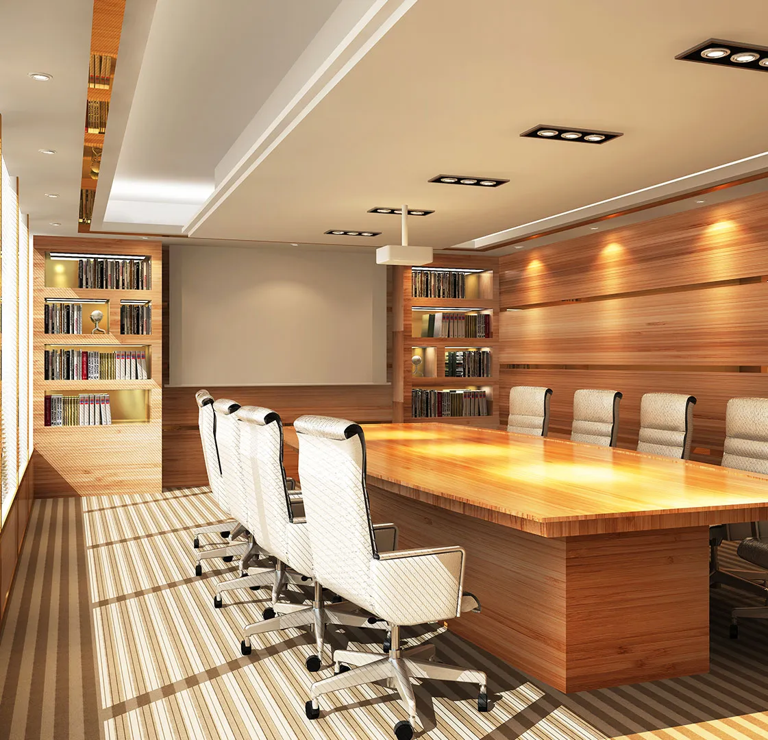 Modern conference room with a large wooden table, white chairs, bookshelves, and warm lighting.