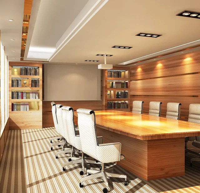 Modern conference room with a large wooden table, white chairs, bookshelves, and warm lighting.