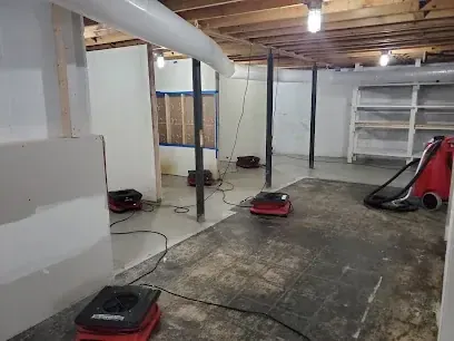 Air movers and dehumidifiers drying a flooded Brockton, MA basement