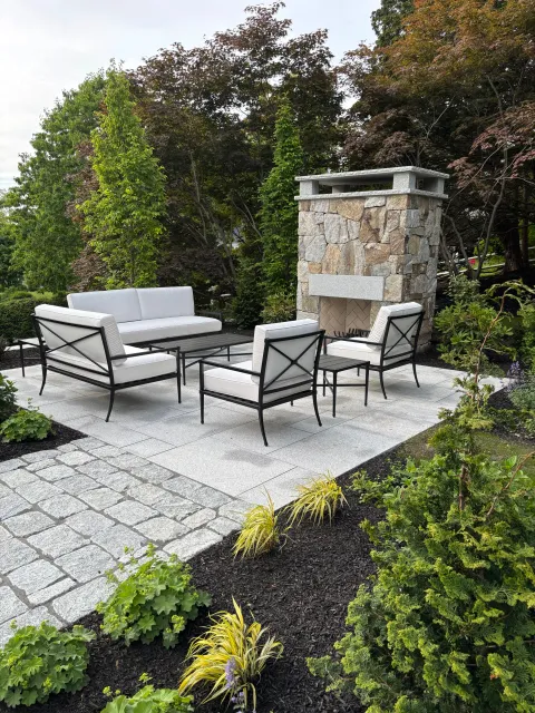 A new granite patio with a stone fireplace, dining area and grill station was added to this unique, historic home.