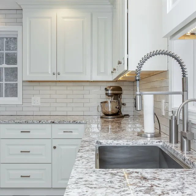 Kitchen remodel with industrial style Moen faucet, undermount sink, and granite countertops in Hampton Falls, NH