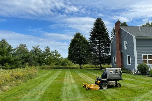 A large commercial lawn mower sitting on a freshly mowed lawn near me