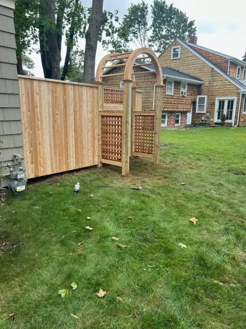 A wooden fence with a gate in the backyard of a house.