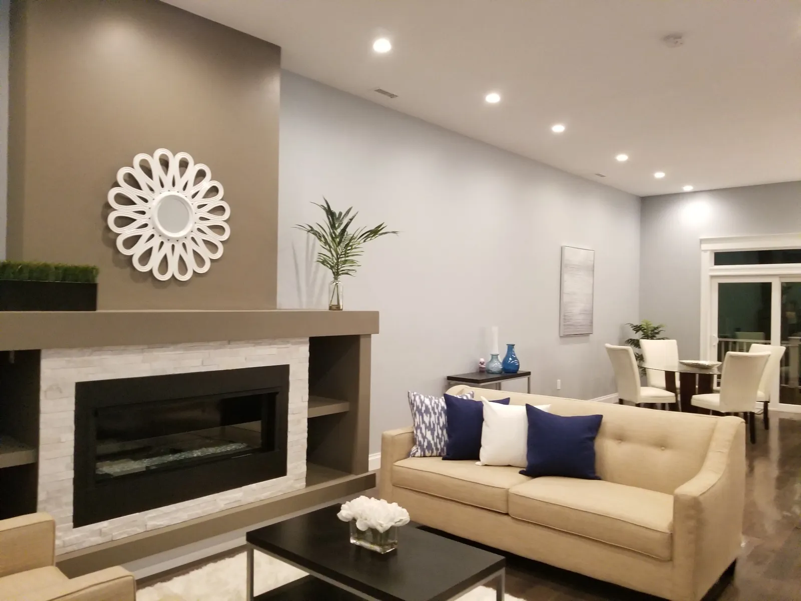 Living room with recessed ceiling lights and illuminated dining area