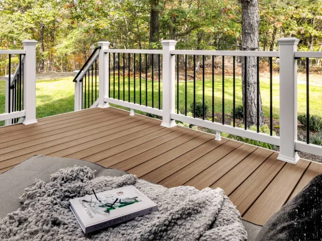 Outdoor deck with white railing and blanket