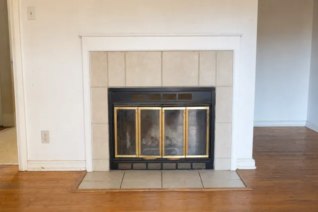 A dated brass-trimmed fireplace ready for replacement