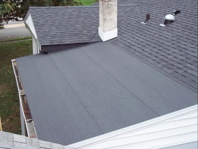 Roofing contractor stripping old shingles on a Greater Boston home