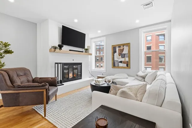 Rare extra-wide penthouse offering 1,778 square feet of beautifully renovated living space, three bedrooms, two-and-a-half baths, two fireplaces, and an exclusive roof deck with sweeping skyline views. The main level features an open living and dining area with red oak hardwood floors, recessed lighting, abundant natural light, and a fireplace. The chef’s kitchen includes quartz countertops, a high-end Thermador appliance package, and a dry bar with beverage refrigerator. A spacious third bedroom and half bath complete this floor. Upstairs, two generous bedroom suites each offer a luxurious en-suite bath with double vanity and ample closet space. One suite also features a fireplace. Additional highlights include in-unit laundry and direct roof-deck access. Ideally located between Boston’s North End and West End, moments from the waterfront, TD Garden, public transportation, downtown, and renowned dining and entertainment.