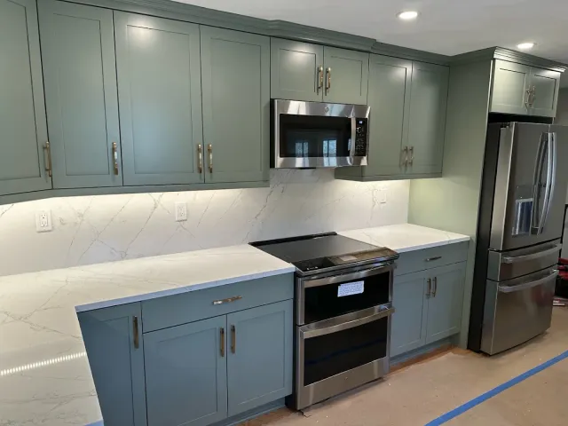 Renovated kitchen with green-grey cabinets, under-cabinet lighting and recessed ceiling lights installed by BW Electrical Contractors