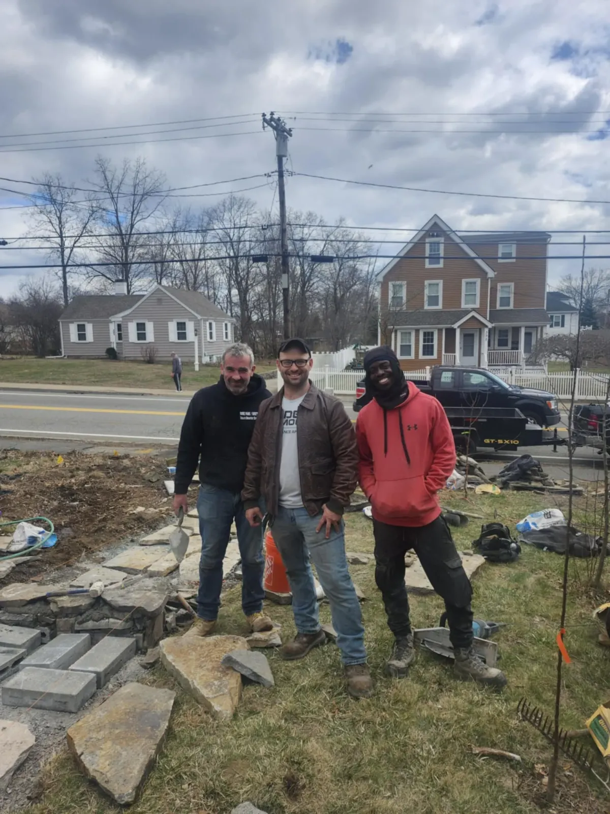 Three Rockhound Masonry team members outside of a work site for a brick walkway and stairs in Norfolk County, MA.