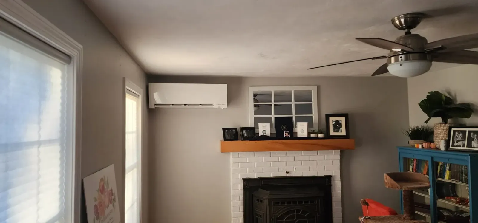 A living room with a fireplace and a ceiling fan.