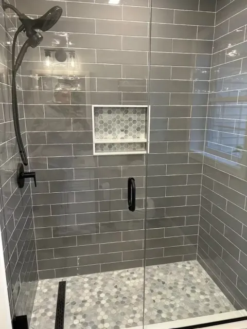 There is a shower with a glass door and a shower head.