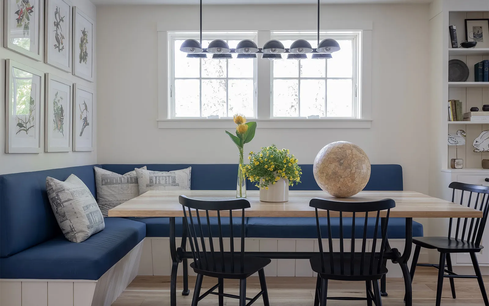 A dining room table with a vase of flowers on top of it