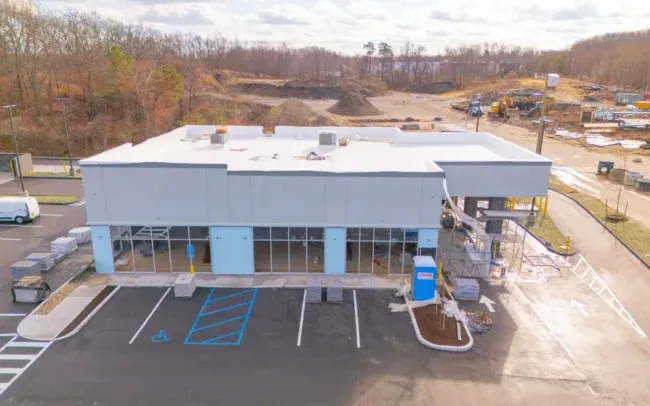 Aerial view of a commercial building under construction with parking spaces in front
