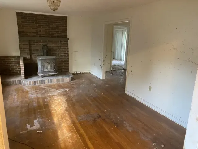 Living room cleared revealing hardwood floors and fireplace