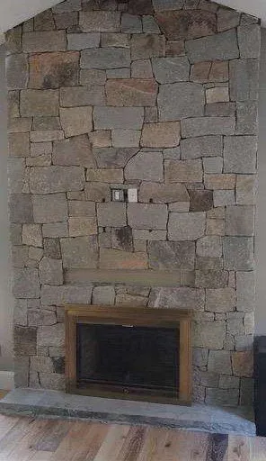 Stone fireplace with wooden frame on a hardwood floor