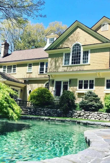A large house with a pool in front of it
