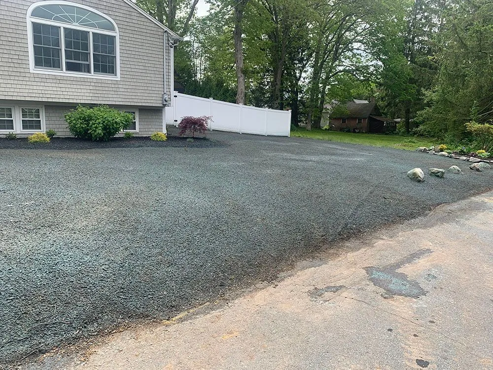 House with trees and gravel driveway.