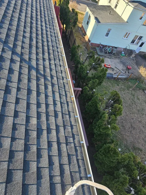 A man is sitting on the roof of a house.