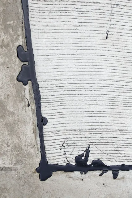 A close up of a concrete surface with black paint on it
