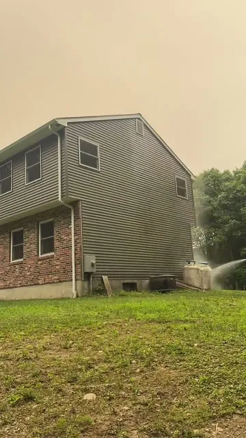 Soft washing the siding of a two-story Connecticut home