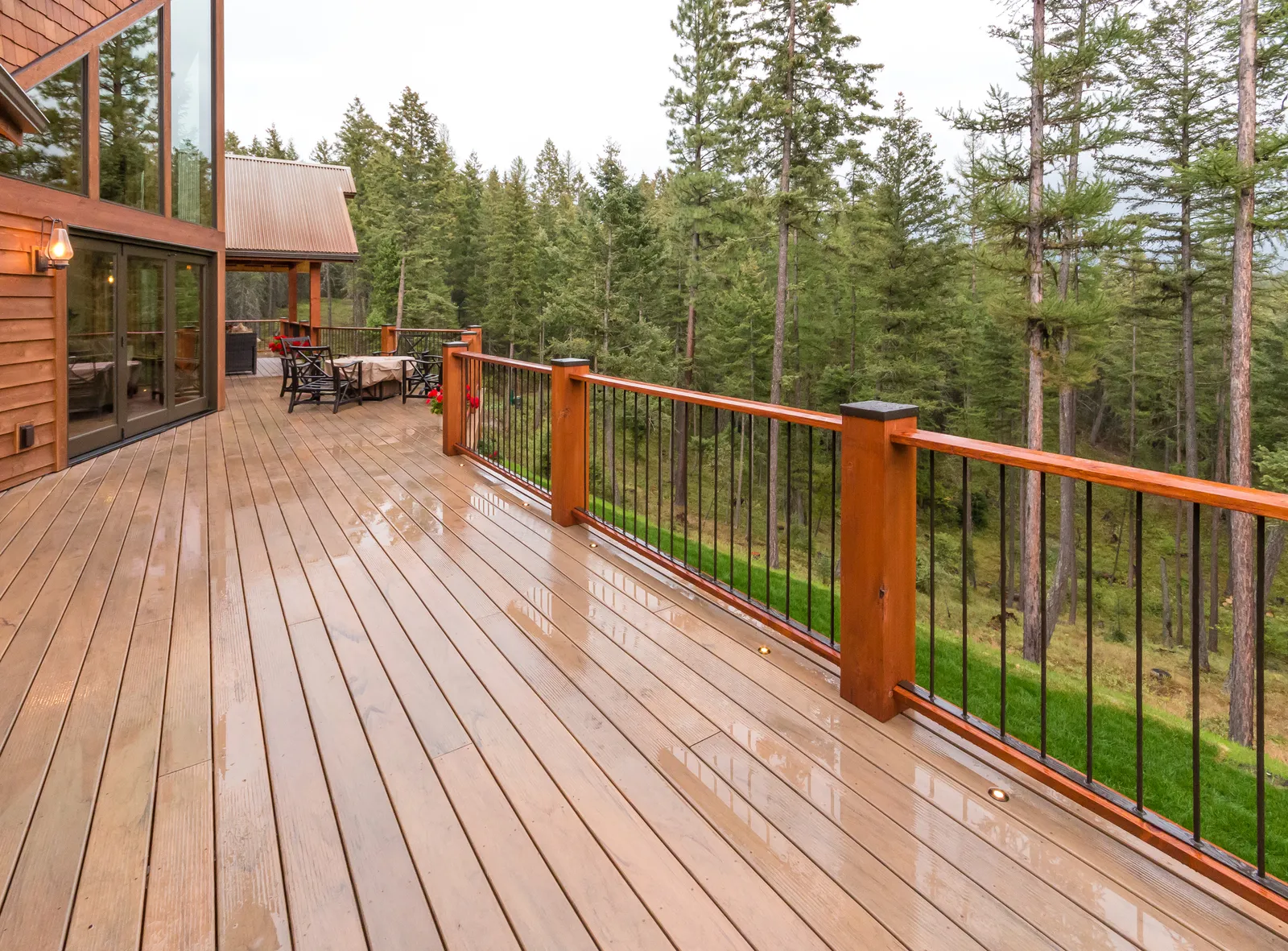 Custom-built composite deck overlooking wooded landscape near Lake Winnipesaukee in New Hampshire, designed and constructed by Bowe Contracting