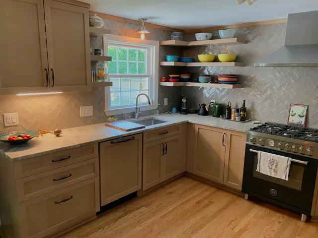 Modern kitchen renovation with custom cabinetry, quartz countertops, open shelving, and stainless steel gas range