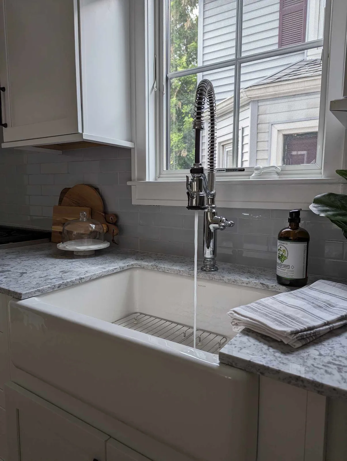 A kitchen sink with water running from the faucet.