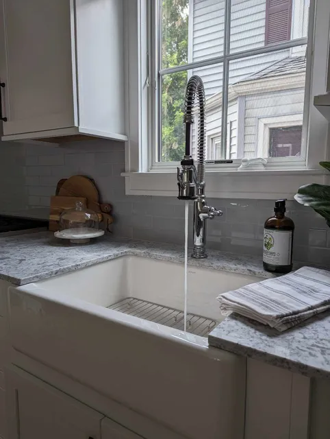 A kitchen sink with water running from the faucet.