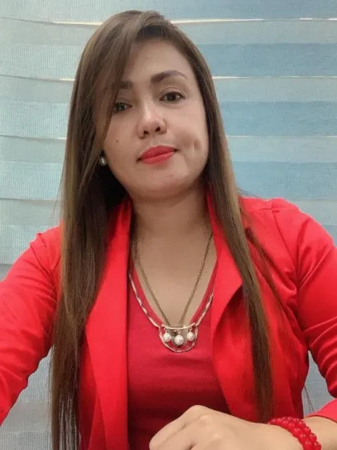Woman with long brown hair wearing a red blazer and necklace.