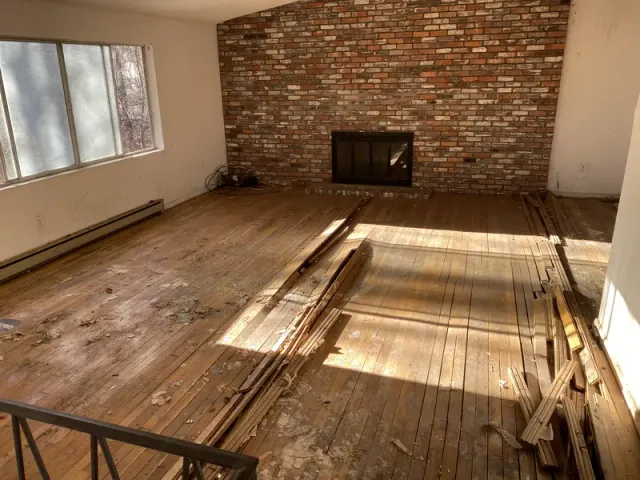Room cleared revealing brick fireplace and hardwood floors
