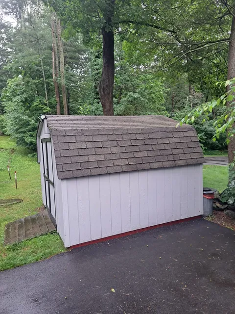 Before — white gable shed before siding and roofing in Sutton, MA