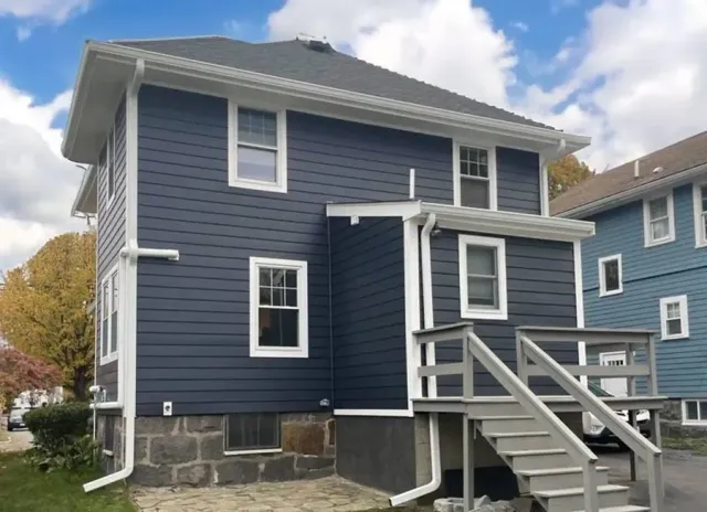 Rear elevation after navy siding, trim and deck stair work