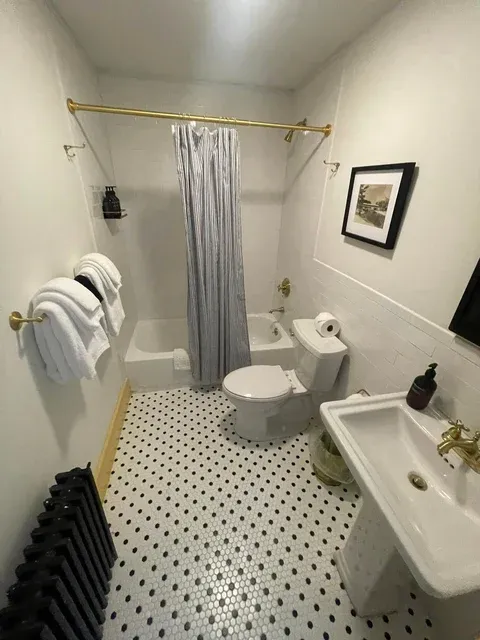 Immaculate white bathroom with penny tile floor — professional cleaning Naples Maine