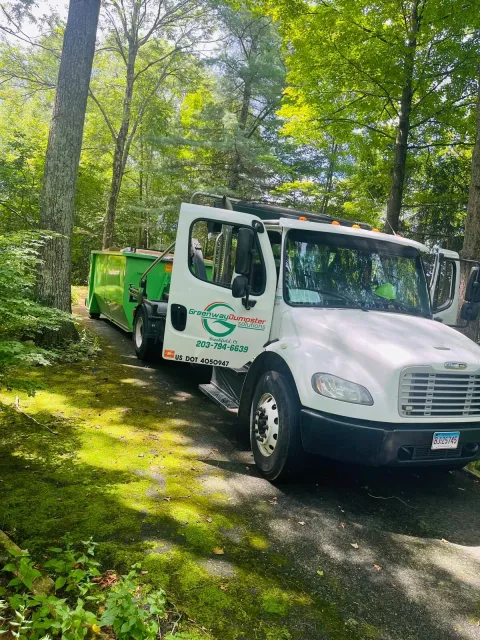 Dumpster pickup in wooded setting