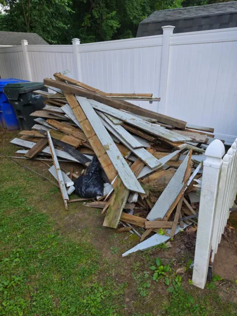 A pile of old boards and lumber before Pioneer Valley Junk Removal hauled it away