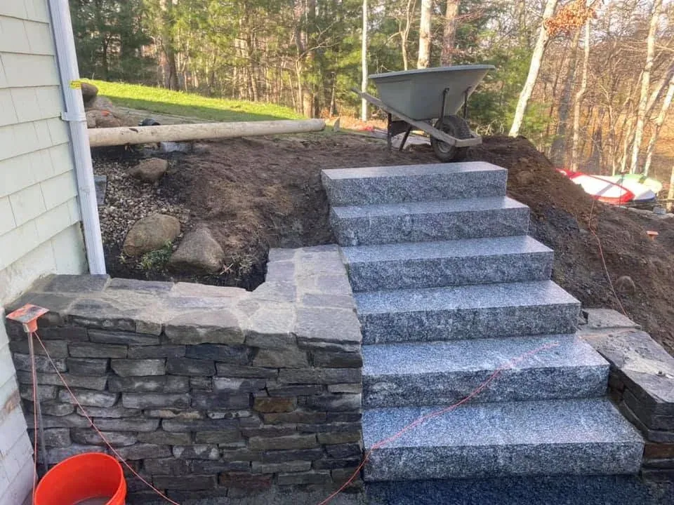 Granite entry steps framed by stacked stone side walls