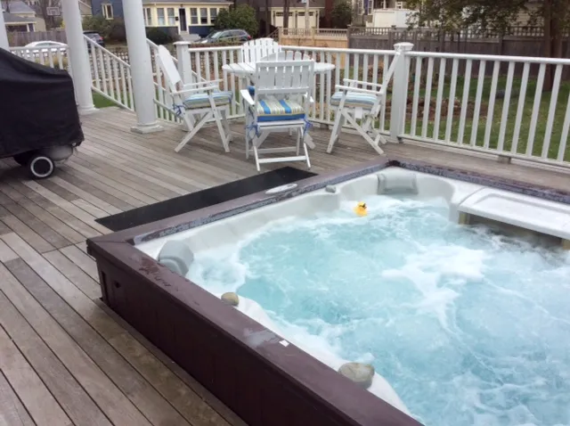 Deck with installed hot tub and railing