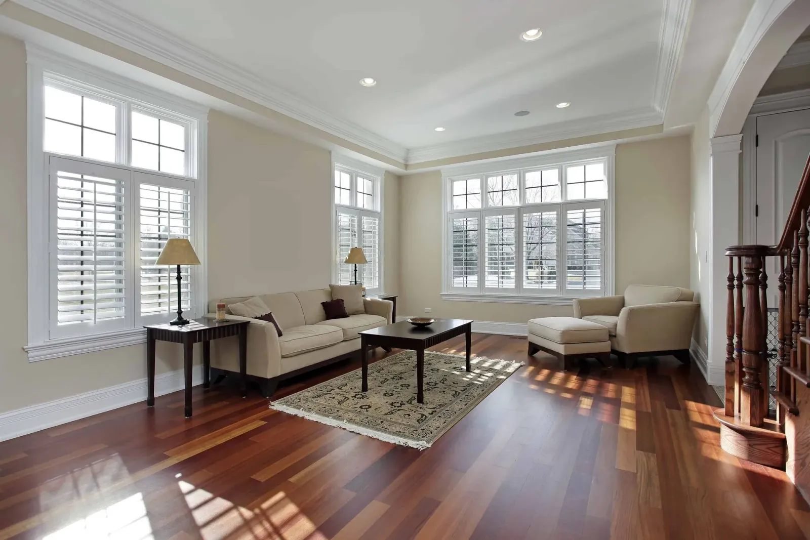 A living room with hardwood floors, a couch, chairs, and a coffee table.