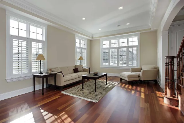 A living room with hardwood floors, a couch, chairs, and a coffee table.