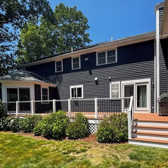 Historic home in Hingham featuring blue siding, double-hung windows, and a welcoming front entry with a porch, showcasing North Star-Bailey's exterior restoration services.