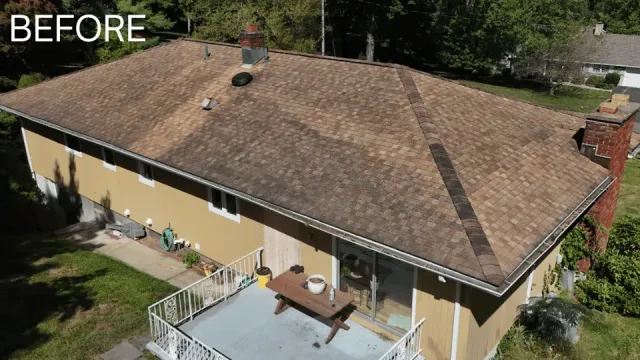 Overhead view of a house with a brown, weathered roof, a yellow exterior, and a deck.