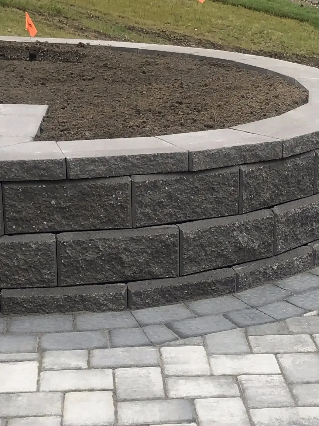 Segmental block retaining wall with a curved face