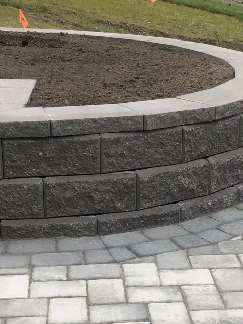 Segmental block retaining wall with a curved face